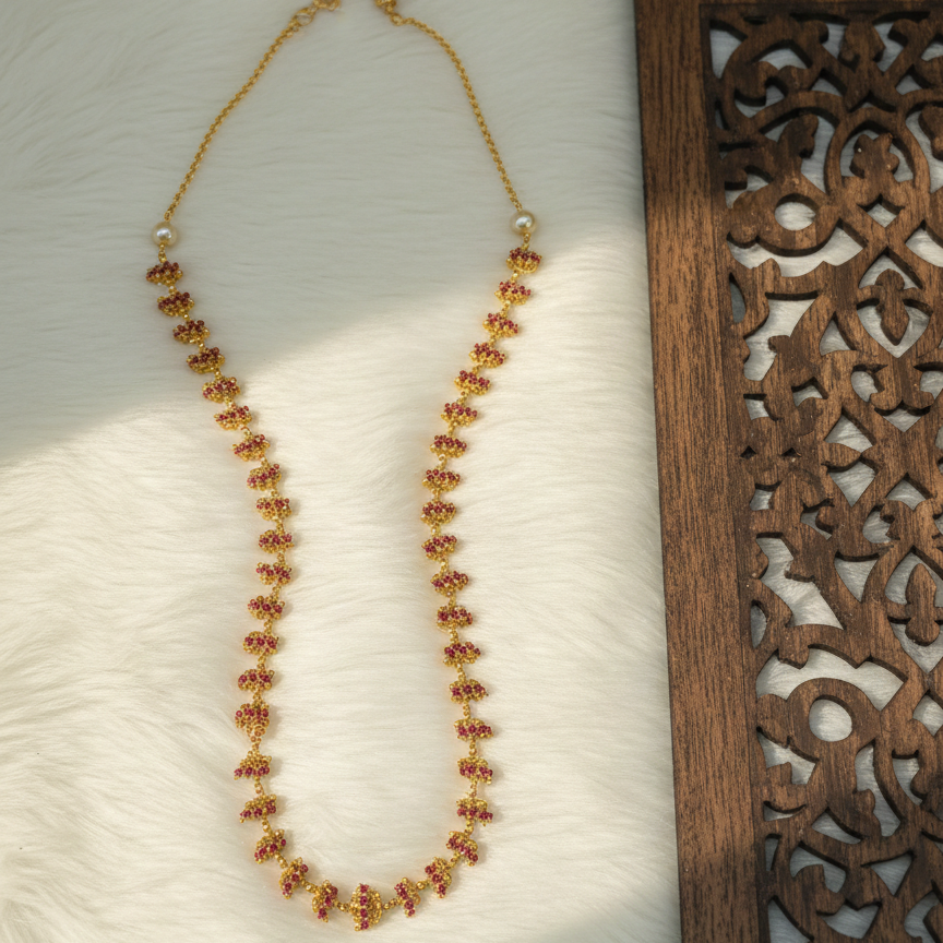 Beaded necklace on a textured surface with a wooden panel in the background