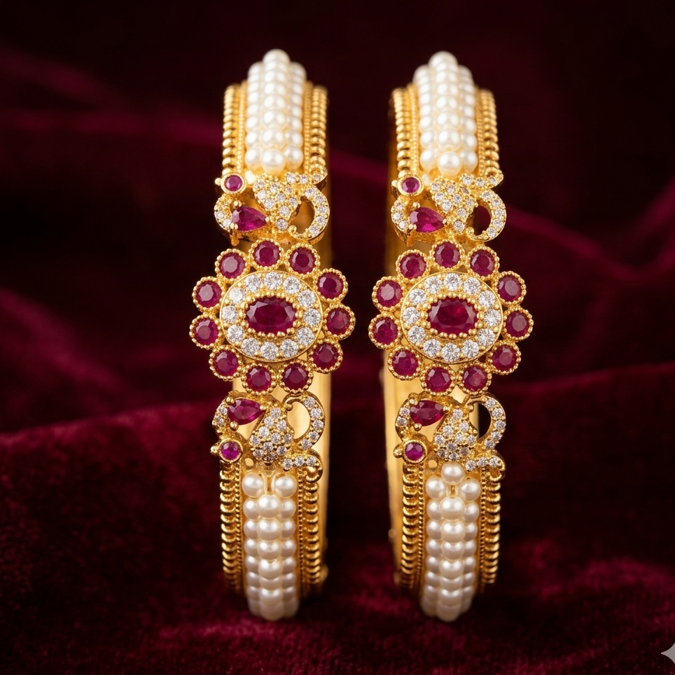 gold bangles with pearls and red stones on a dark red fabric background
