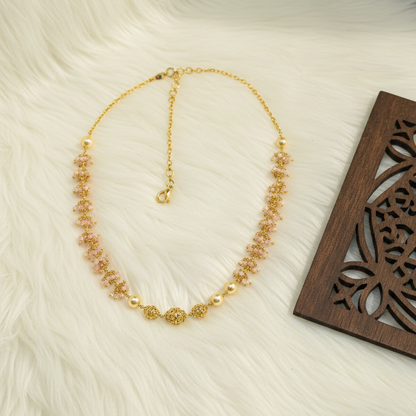 Gold necklace on a white fur surface with a wooden tray