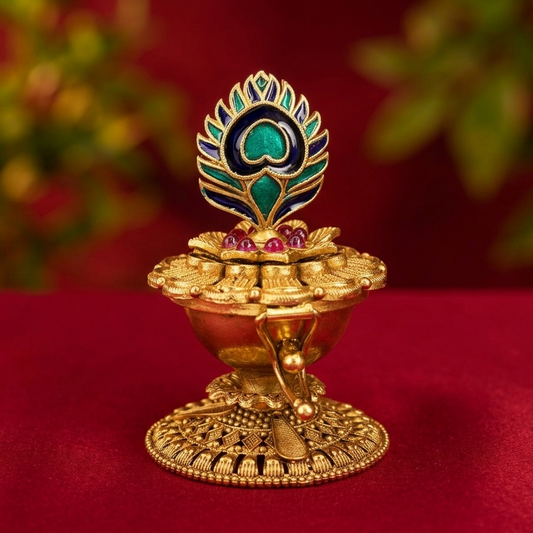 Decorative gold oil lamp with peacock design on a red background